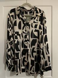 black-and-white geometric print blouse features a sharp collar and a distinctive lace-up front tie detail.