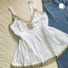 white sleeveless peplum top featuring delicate beige lace trim along the V-neckline and hem