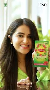 Lipton Green Tea Raspberry Mint flavored tea bags featuring a vibrant green and pink packaging with graphic raspberries and leaves